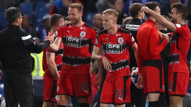 Huddersfield's players and management celebrate after securing Premier League safety