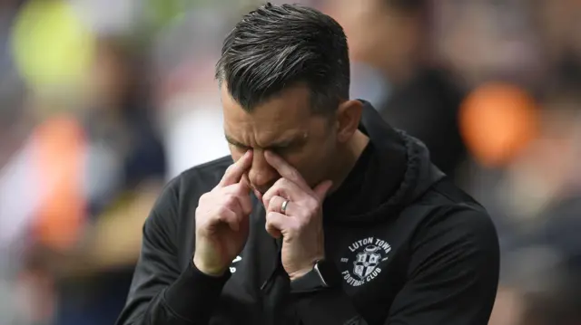 Luton Town boss Matt Bloomfield pinches the bridge of his nose as he looks down in frustration