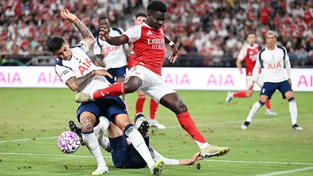 Bukayo Saka of Arsenal is challenged by Cristian Romero and Rodrigo Bentancur of Tottenham Hotspur during the Pre-Season Friendly match between Arsenal and Tottenham Hotspur at Kai Tak Sports Park