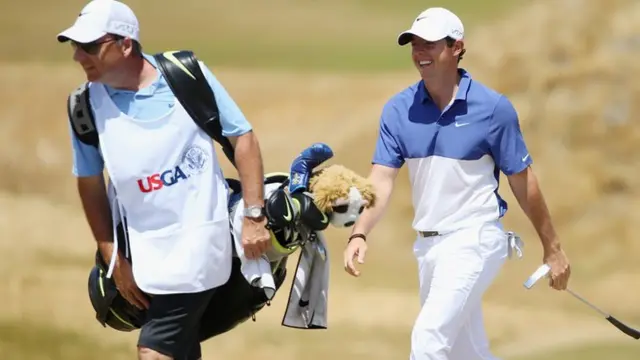 Rory McIlroy walks with his caddie