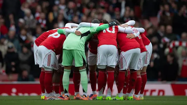 Arsenal team huddle at the Emirates Stadium, London