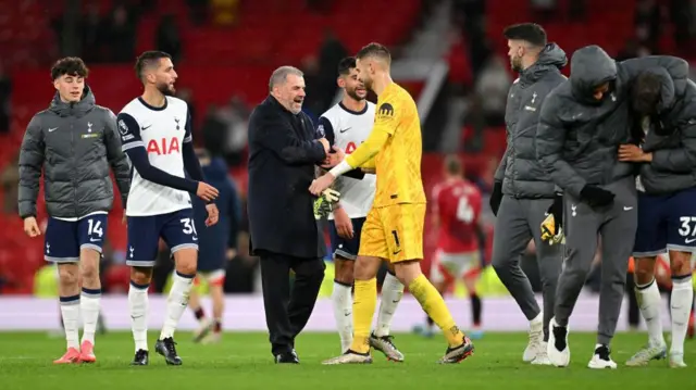 Ange Postecoglou embraces his Tottenham players after victory at Old Trafford