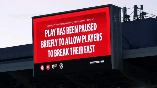 Brentford board stating: "Play has been paused briefly to allow players to break their fast."