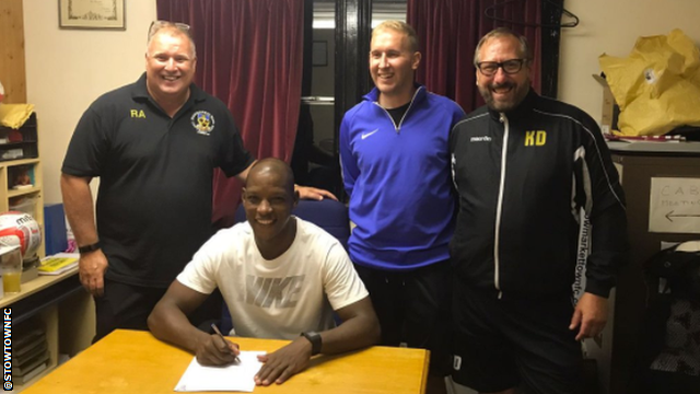 Titus Bramble (centre) signing for Stowmarket Town