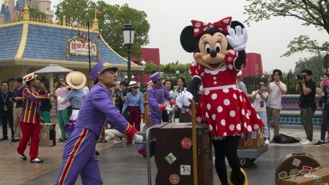 Man wheeling Minnie Mouse on trolley