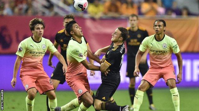 Man City and Wolves players tussle for the ball