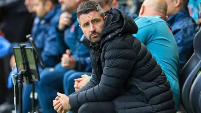 Alan Sheehan sits in the dugout