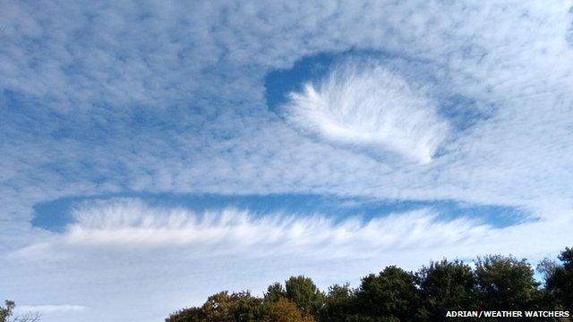 A two hole punch clouds, one more elongated than the other
