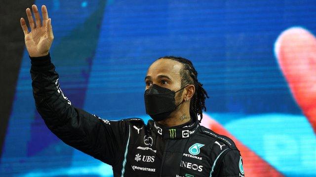 Lewis Hamilton waves at a crowd