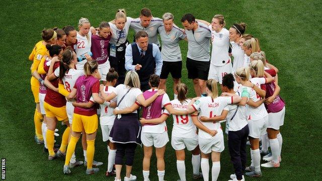 England boss Phil Neville talks to his players on the pitch after the Scotland game