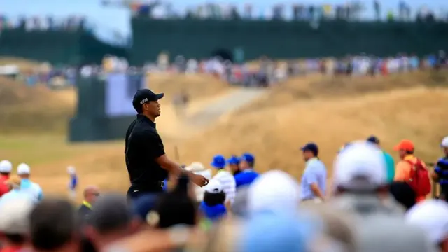 Tiger Woods walks to his first tee