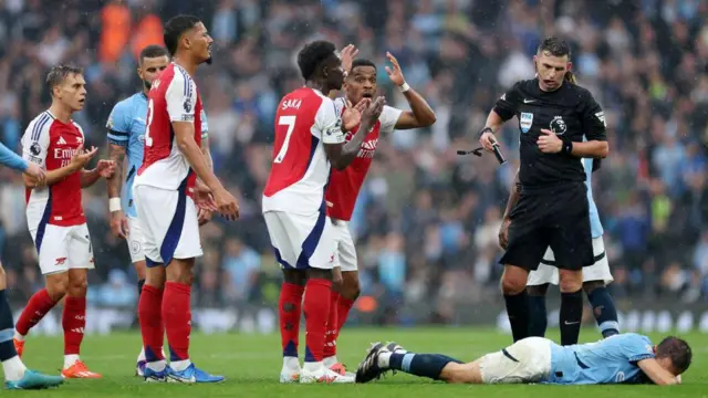 Bernardo Silva of Manchester City reacts prior to Referee, Michael Oliver showing a red card to Leandro Trossard of Arsenal