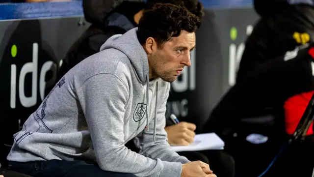 Ryan Mason leans forward in the West Bromwich Albion dugout during a match