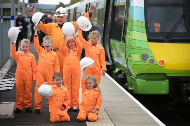 Primary 3 school children from St Andrew's Primary School in Gorebridge pose at the soon-to-be-opened Newtongrange train station wearing orange boiler suits and hard hats, representing the region's coal mining heritage.