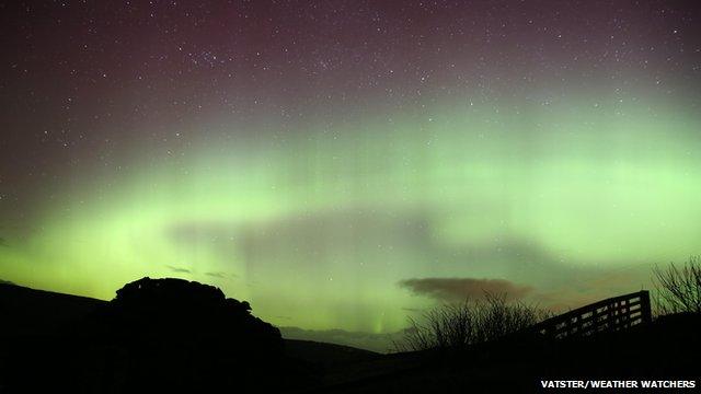 Green glow of the Northern Lights in the night sky