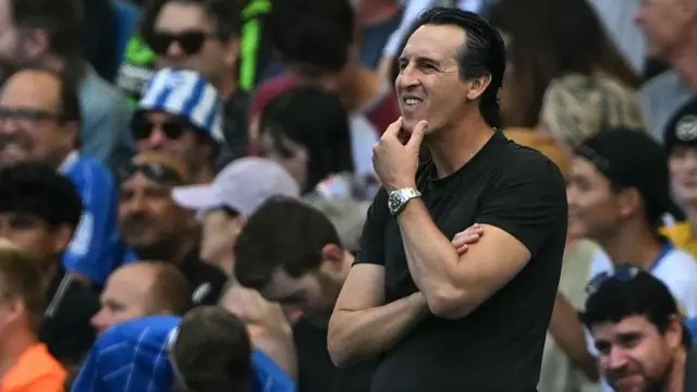Unai Emery with his hand on his chin looking pensive on the touchline at Brighton