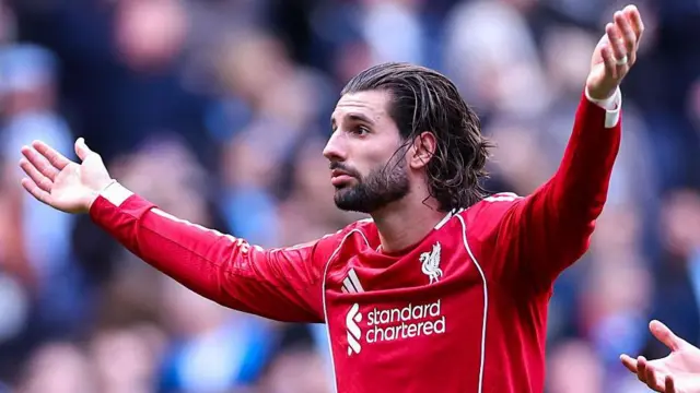 Dominik Szoboszlai waves his arms in protest at fans