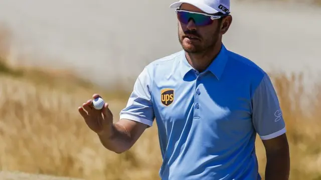 Louis Oosthuizen holds up his ball