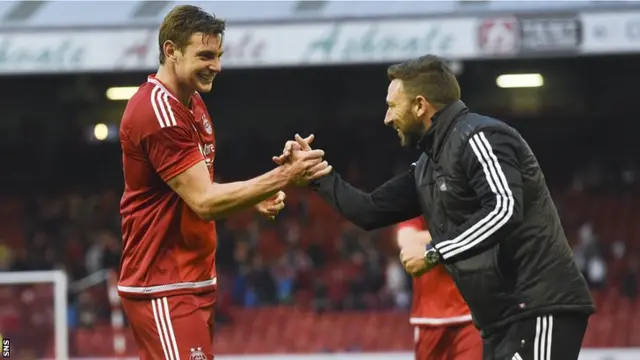 Aberdeen defender Ash Taylor celebrates with manager Derek McInnes