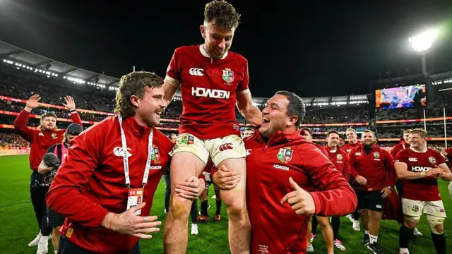 Hugo Keenan of British & Irish Lions is held aloft by Mack Hansen, left, and Jamie George