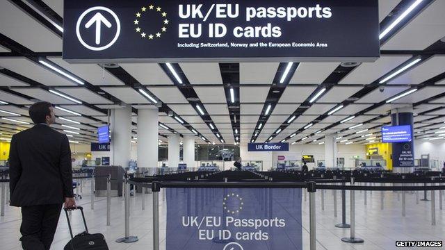 man looking up at passport control sign