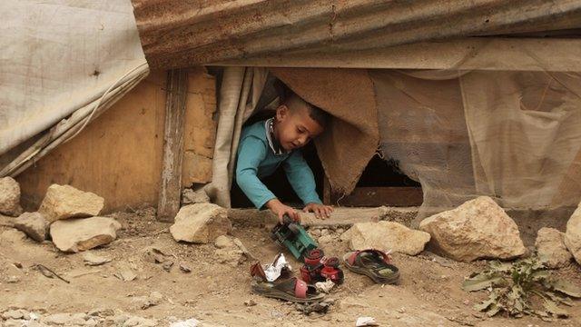 A Syrian refugee boy plays outside his family tent, during a sandstorm, in a refugee camp in the town of Bar Elias, in Lebanon"s Bekaa Valley