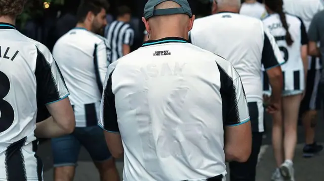 A fan wearing a ruined Alexander Isak Newcastle shirt