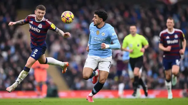 Omar Marmoush runs with the ball under pressure from Kieran Trippier