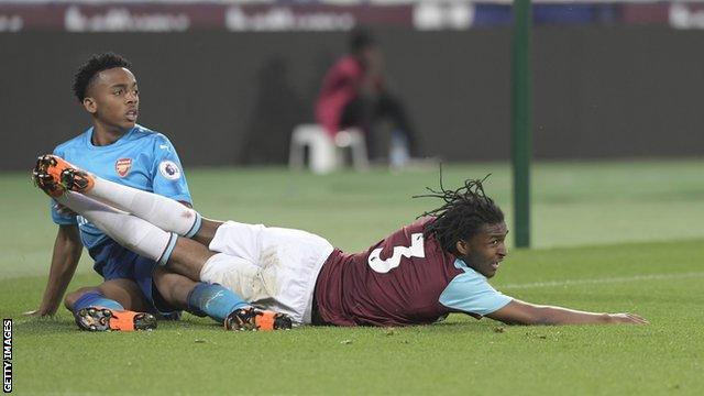 Vashon Neufville of West Ham United and Joe Willock of Arsenal both land on the ground during the Premier League 2 match between West Ham United and Arsenal at London Stadium on April 20, 2018