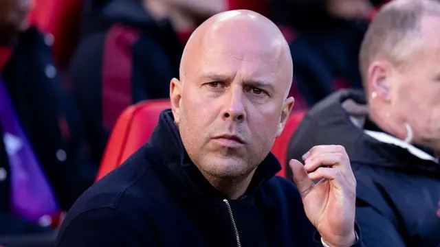 Arne Slot looking serious while sitting on the bench