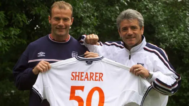 Alan Shearer and Kevin Keegan both hold an England shirt which reads 'Shearer 50' on the back