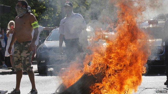 Striking taxi drivers in Paris standing by a burning tyre during a protests against app-based taxi company Uber