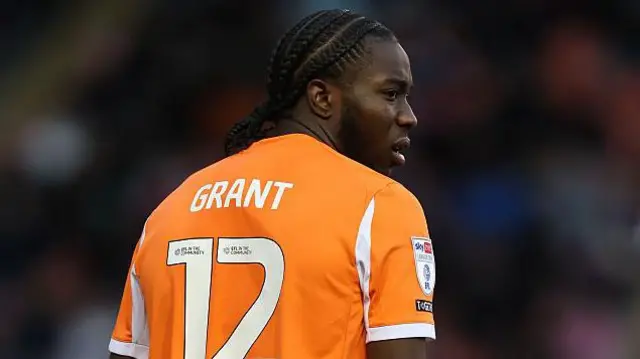 Millwall defender Kamarl Grant pictured in Blackpool's tangerine strip, bearing the number 12 and his surname.