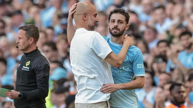 Pep Guardiola, manager of Manchester City, embraces Bernardo Silva