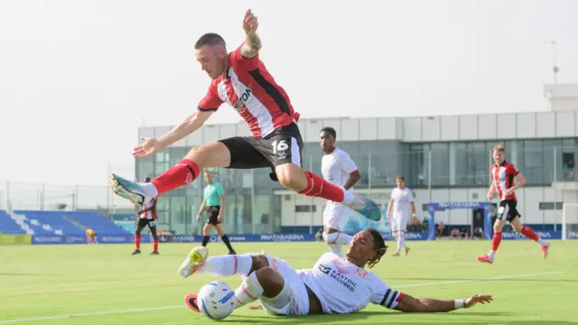 Lincoln City's Dom Jefferies jumps past Leyton Orient's Sean Clare as the latter puts in a tackle during their pre-season friendly in Spain on Friday.
