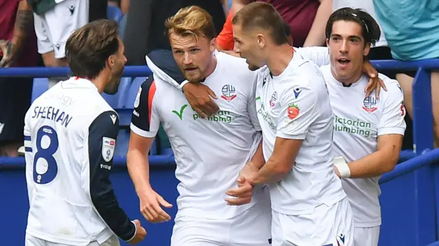 Bolton players, wearing their white home shirt, celebrate a goal against Preston
