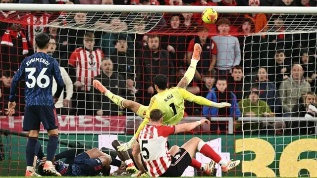 David Raya falling back down with his legs in the air after attempting to stop Brian Brobbey scoring for Sunderland