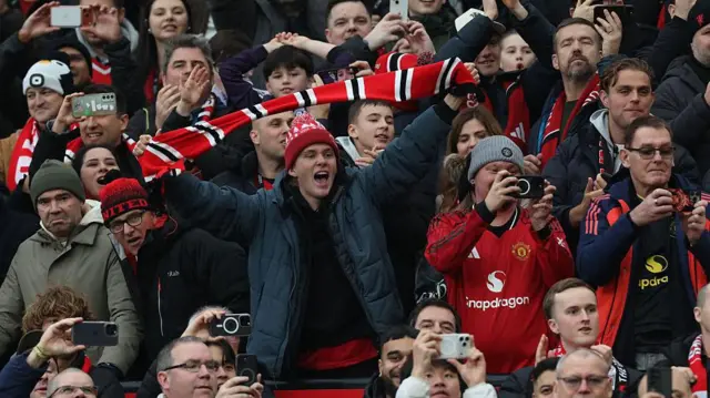 Manchester United fan holds up scarf among crowd