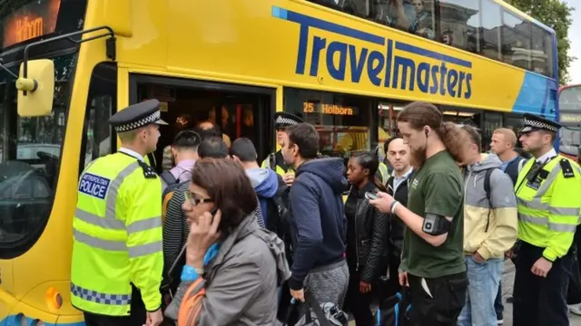 People queue for a bus at Stratford station