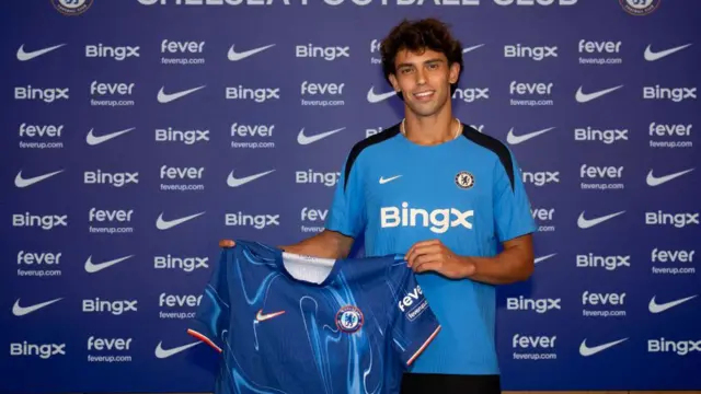 Joao Felix holding a Chelsea shirt after signing for the club