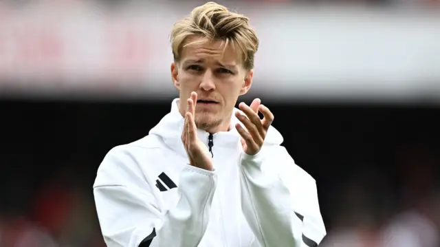 Martin Odegaard claps the fans as he walks across the Emirates pitch