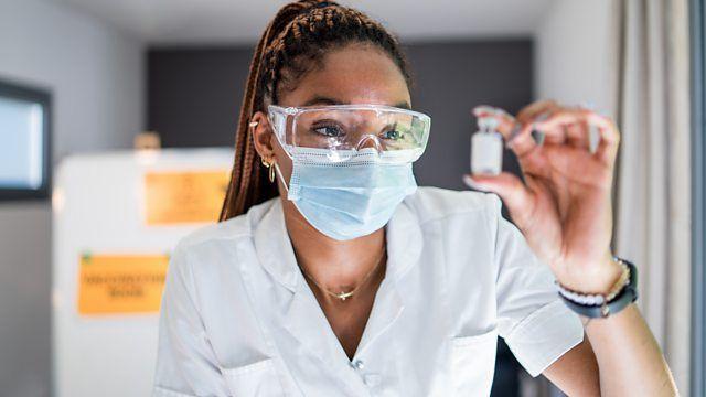 a scientist holding a vial