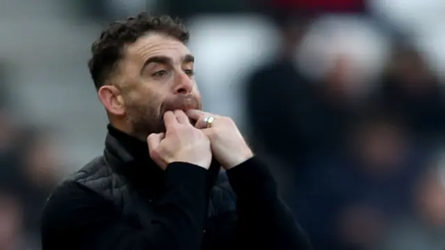 Omer Riza with fingers in mouth whistling