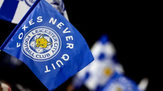 Leicester City flag which says 'Foxes Never Quit'