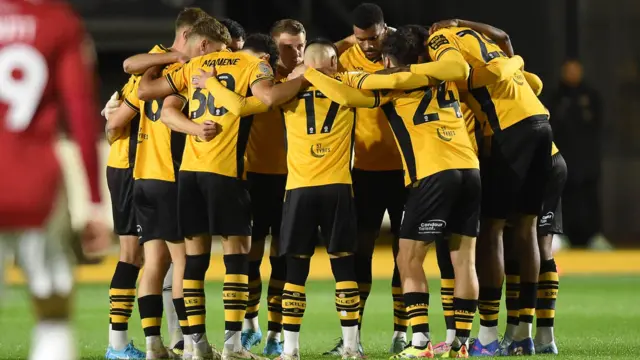 Newport players in a huddle before their win over Salford