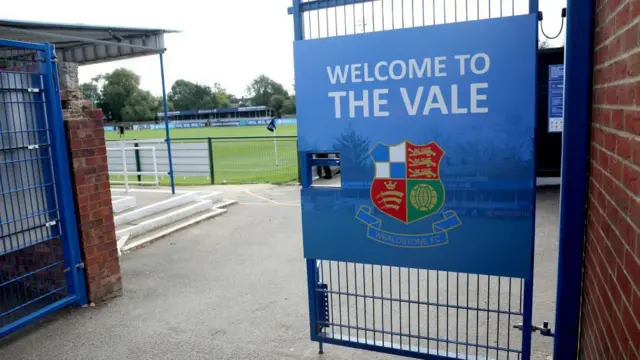 An image showing the front gate at Grosvenor Vale stadium, with the pitch in the background.