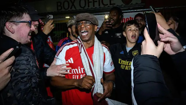 Ian Wright celebrating with Arsenal fans in the streets around Emirates Stadium