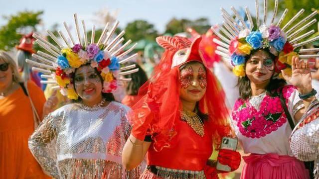 Three women wearing colourful traditional outfits