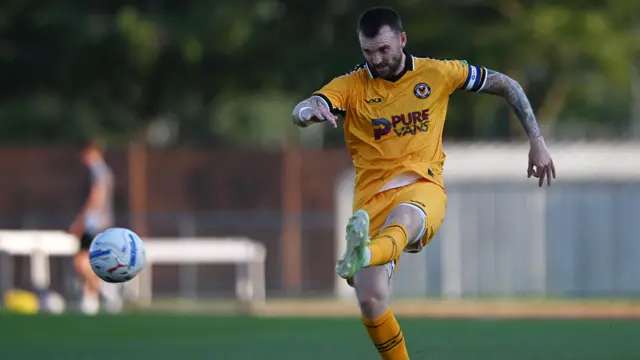 Kyle Cameron kicks the ball with his left foot in Newport County's pre-season game at Newport City