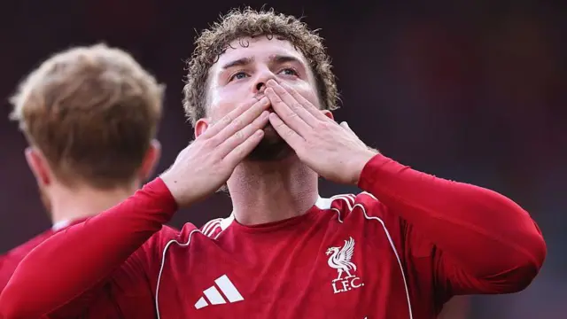 Harvey Elliott blows a kiss to the crowd in his Liverpool shirt